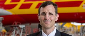 Tobias Meyer, Vorstandsvorsitzender von DHL, steht im Frachtzentrum am Flughafen Leipzig/Halle vor einem Airbus A330. 