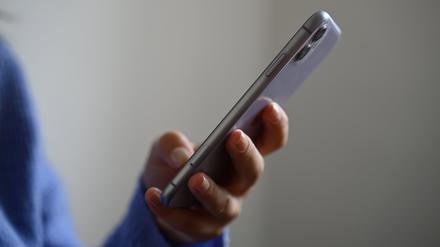 Eine Frau hält ein Smartphone in der Hand.