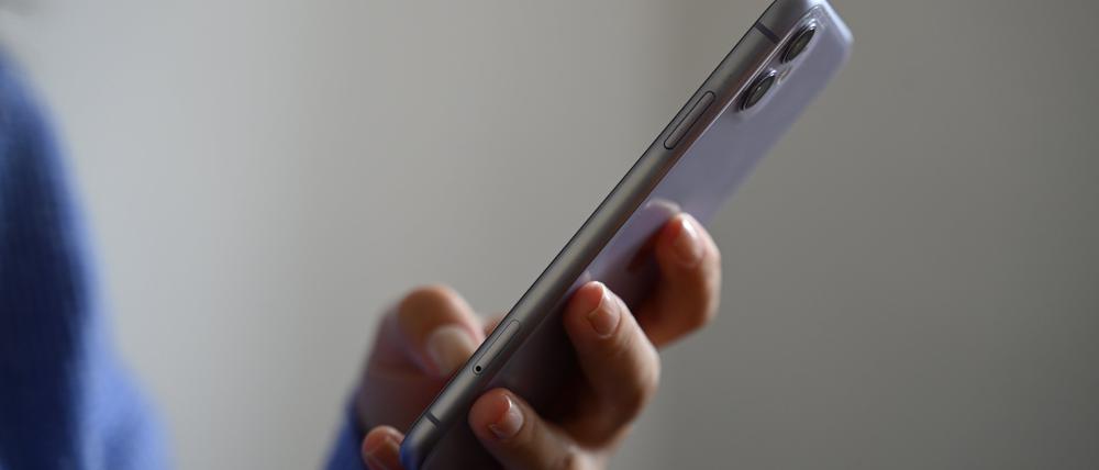 Eine Frau hält ein Smartphone in der Hand.