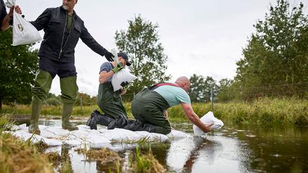 Durch einen Schutzdeich in Eisenhüttenstadt sickert Wasser. Einsatzkräfte rücken mit  Sandsäcken an.