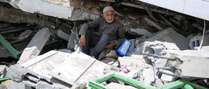 Ein Mann sitzt in Gaza-Stadt inmitten der Ruinen eines zerstörten Gebäudes. 