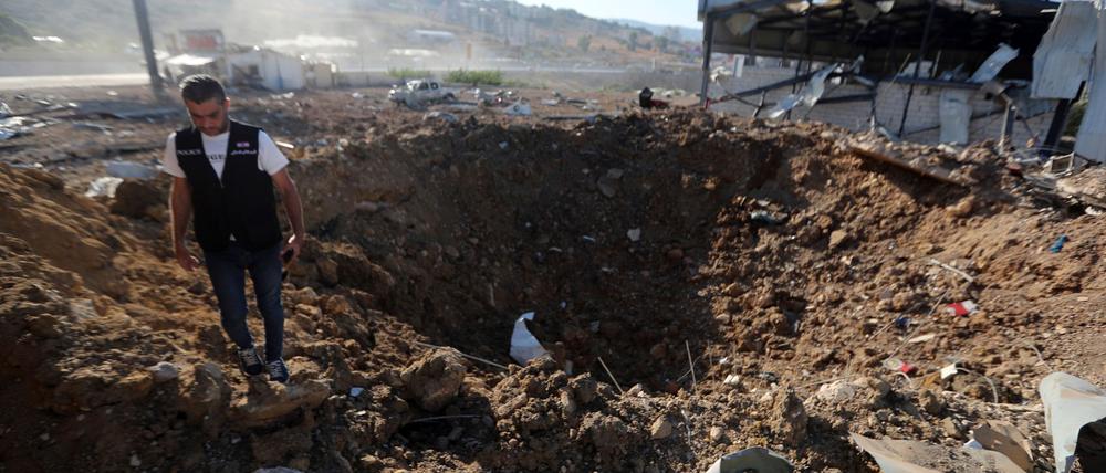 Ein libanesischer Polizist steht in der Nähe eines Kraters nach einem israelischen Luftangriff auf einen Hangar im Südlibanon.