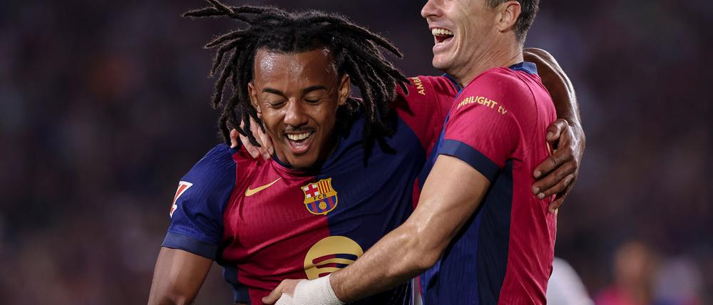 Jubel über das 6.500. Ligator in der Geschichte des FC Barcelona: Torschütze Robert Lewandowski (r) feiert mit Jules Kounde.