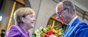 Friedrich Merz, CDU-Bundesvorsitzender und Unionsfraktionsvorsitzender, überreicht Angela Merkel beim Berliner Gespräch Spezial zum 70. Geburtstag der früheren Bundeskanzlerin einen Blumenstrauß. 