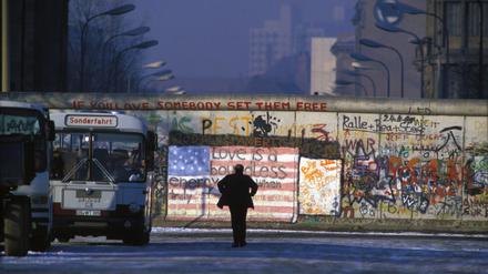 Ein Mann schaut auf die Berliner Mauer, 1986.