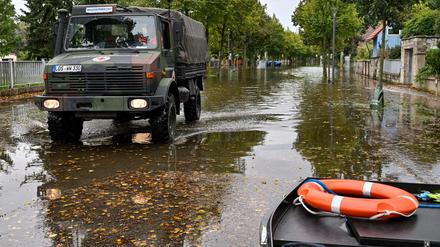 Mit einem Unimog sind Einsatzkräfte in Frankfurt (Oder) unterwegs, um Bewohner aus einer überfluteten Straße zu bringen.
