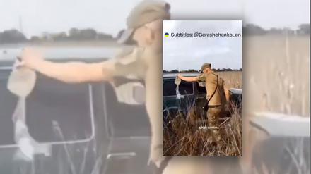 Ein russischer Soldat leert eine brennbare Flüssigkeit über ein Auto.