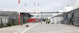 Bewohner und Mitarbeiter gehen im Ankunftszentrum am ehemaligen Flughafen Tegel in Richtung der Leichtbauhallen. (Archvibild)