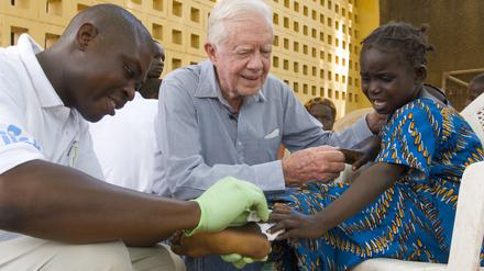 Der Präsident als Krankenschwester: Jimmy Carter versucht, die sechsjährige Ruhama Issah im Savelugu Hospital in Ghana zu beruhigen, während ein Pfleger sich um ihre extrem schmerzhafte Guinea-Wurm-Wunde kümmert. Savelugu, Ghana, 8. Februar 2007.