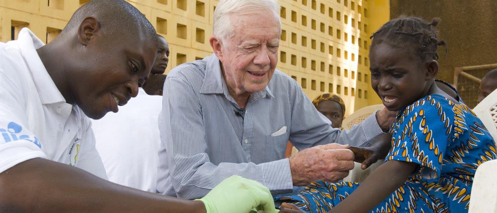 Der Präsident als Krankenschwester: Jimmy Carter versucht, die sechsjährige Ruhama Issah im Savelugu Hospital in Ghana zu beruhigen, während ein Pfleger sich um ihre extrem schmerzhafte Guinea-Wurm-Wunde kümmert. Savelugu, Ghana, 8. Februar 2007.