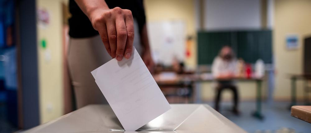 Eine Erstwählerin wirft einen Wahlzettel in eine Wahlurne. Symbolbild.