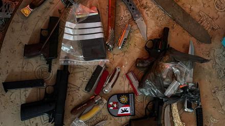 Die Beamten platzieren das Waffenarsenal des 33-Jährigen auf einem Tisch.