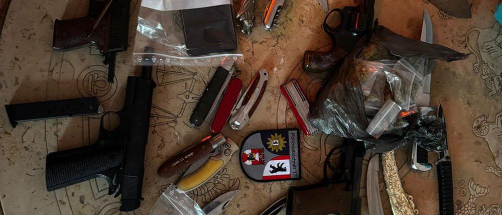 Die Beamten platzieren das Waffenarsenal des 33-Jährigen auf einem Tisch.