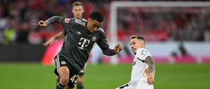 Bayern-Profi Jamal Musiala (links) dribbelt an Leverkusens Alejandro Grimaldo vorbei.