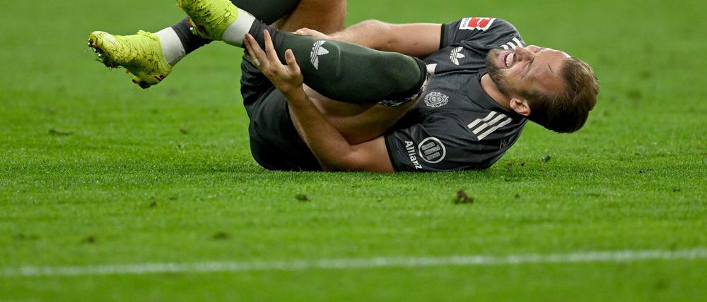 Bayern-Stürmer Harry Kane hält sich nach einem Zweikampf den Knöchel.
