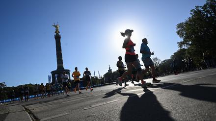 Läufer laufen vor der Siegessäule. 