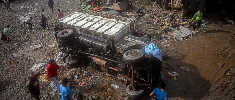 Ein beschädigtes Fahrzeug liegt inmitten von Schlamm und Trümmern in einem vom Hochwasser betroffenen Gebiet nach schweren Monsunregenfällen in Kathmandu auf der Seite.