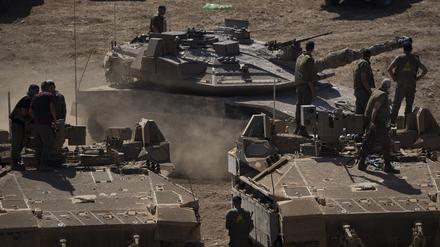 Ein israelischer Panzer fährt im Norden Israels neben Soldaten, die auf einem gepanzerten Mannschaftstransportwagen (APC) stehen. 