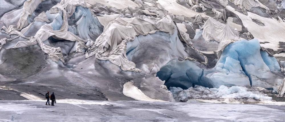 Mitarbeiter des ETH-Glaziologen und Leiters des Schweizer Messnetzes «Glamos», Matthias Huss, treffen am teilweise bedeckten Rhonegletscher in der Nähe des Goms in der Schweiz ein.