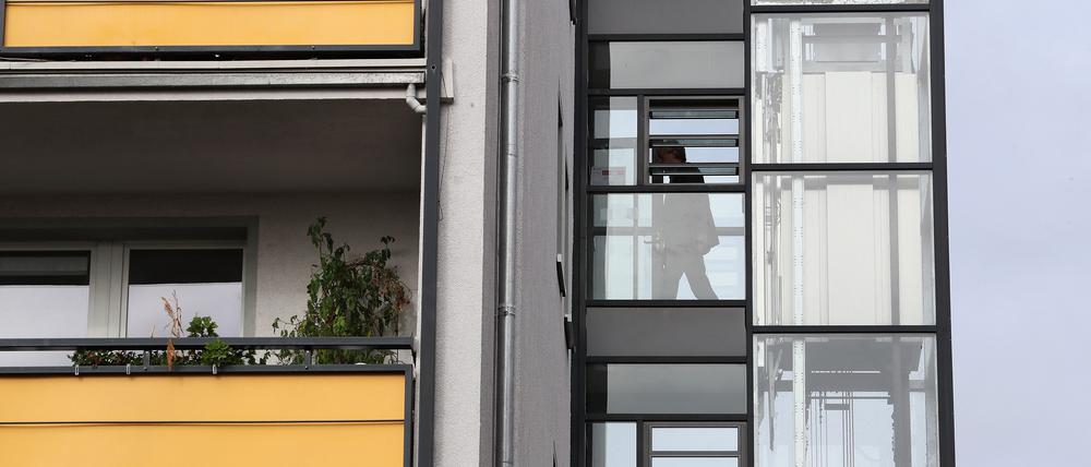 Ein neu angebrachter Außenaufzug an einem Plattenbau.