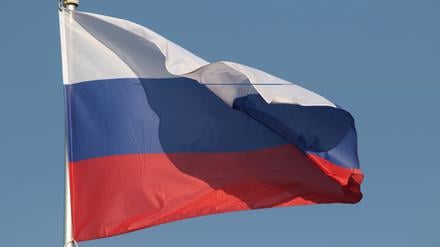 Die Nationalflagge der Russischen Föderation flattert im Wind an einem Fahnenmast in Sankt Petersburg, Russland.