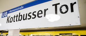 Eine U-Bahn der Linie 8 steht im Bahnhof Kottbusser Tor, während Fahrgäste ein- und aussteigen. 