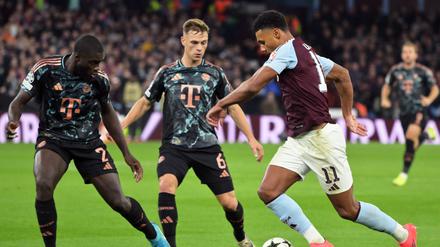 Liefern sich stellvertretend für ihre Teams einen harten Kampf: Die Münchner Dayot Upamecano (l) und Joshua Kimmich sowie Villas Ollie Watkins.