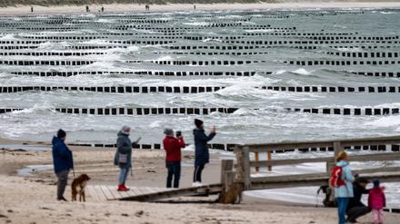 Stürmische Zeiten: Touristen am Strand im Ostseebad Zingst