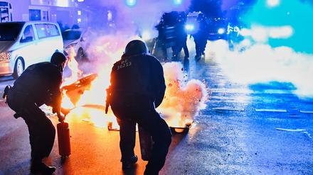 Polizeibeamte versuchen auf der Sonnenallee in Berlin-Neukölln zwei in Brand gesetzte Mülltonnen zu löschen. In der Sonnenallee kam es zu teilweise gewalttätigen Auseinandersetzungen von Menschen, die „Freiheit für Palästina“ skandierten. (Archivbild)