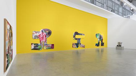 Aufmarsch der Ömega-Men vor gelber Wand: als etwas wurstig-wulstige Varianten des letzten Buchstabens im griechischen Alphabet. Blick in die Ausstellung von Albert Oehlen in der Galerie Hetzler.