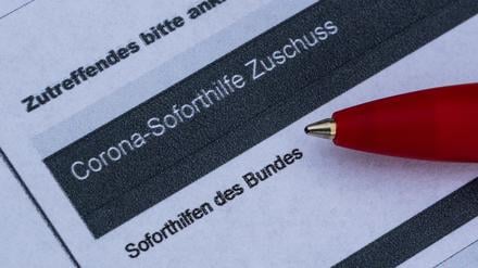 Ein Stift liegt auf einem Antrag für den Corona-Soforthilfe-Zuschuss. 