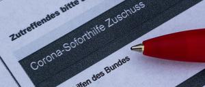 Ein Stift liegt auf einem Antrag für den Corona-Soforthilfe-Zuschuss. 