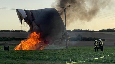 Eine Ballonhülle von einem Heißluftballon blieb beim Landeversuch auf einem Acker an einer Stromleitung hängen und fing Feuer. 