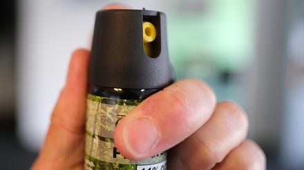 Eine Hand hält eine Kartusche mit Pfefferspray. (Symbolbild)