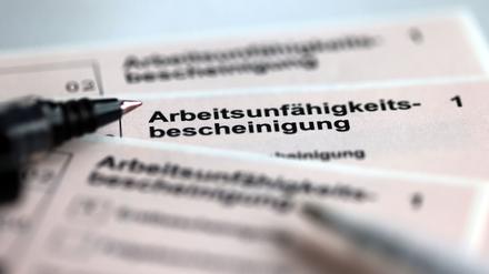 Stifte liegen auf den Arbeitsunfähigkeitsbescheinigungen für Arbeitnehmer im Falle einer Krankschreibung durch den Arzt. 