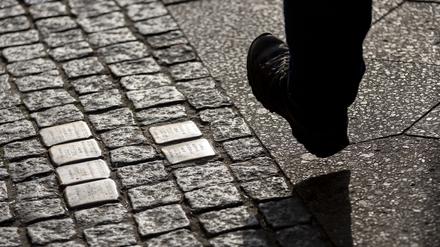 Ein Mann geht an Stolpersteinen vorbei. (Symbolfoto)