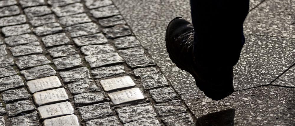 Ein Mann geht an Stolpersteinen vorbei. (Symbolfoto)