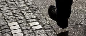 Ein Mann geht an Stolpersteinen vorbei. (Symbolfoto)