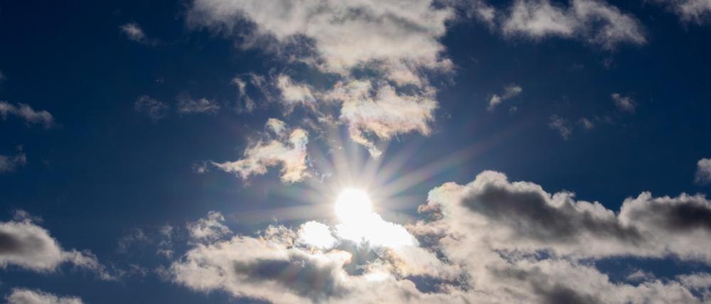 Die Sonne scheint zwischen Wolken hindurch. (Symbolbild)