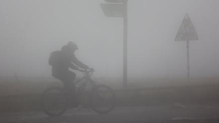 Schierke: Ein Fahrradfahrer ist bei Sturm und Regenwetter auf dem Brocken unterwegs.