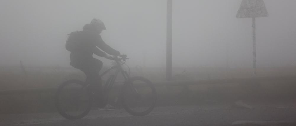 Schierke: Ein Fahrradfahrer ist bei Sturm und Regenwetter auf dem Brocken unterwegs.