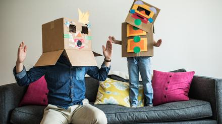 Vater und Tochter mit Roboter-Kostüm zu Hause. 