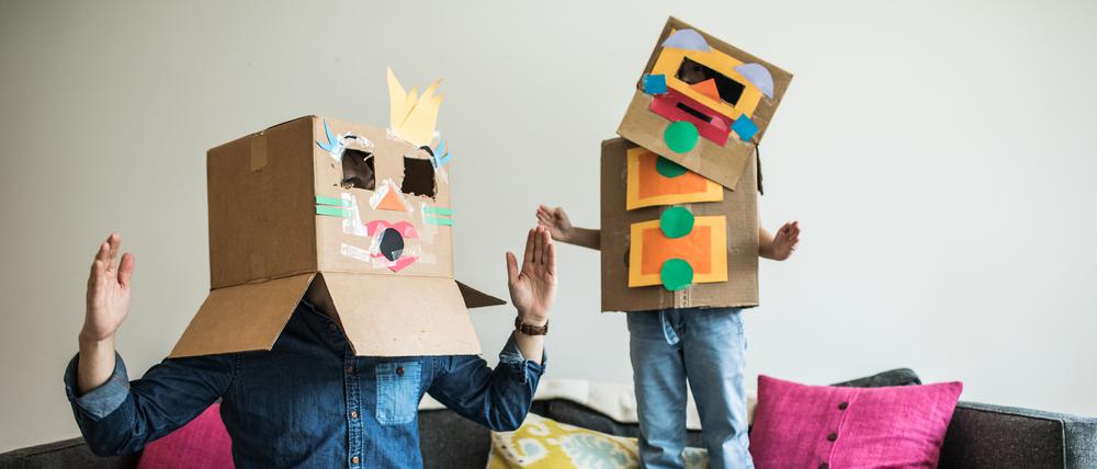 Vater und Tochter mit Roboter-Kostüm zu Hause. 