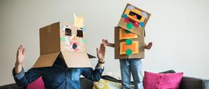 Vater und Tochter mit Roboter-Kostüm zu Hause. 