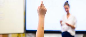 Ein Schüler in einem Klassenraum in Hannover meldet sich per Handzeichen.