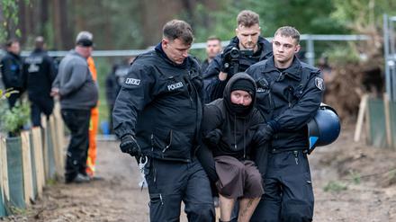 Polizisten nehmen nach einer Besetzung eines Baufahrzeuges Umweltaktivisten im Wald am Tesla Werk fest. 