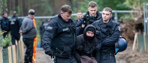 Polizisten nehmen nach einer Besetzung eines Baufahrzeuges Umweltaktivisten im Wald am Tesla Werk fest. 