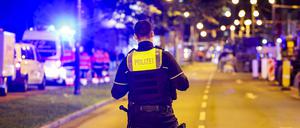 Ein Polizist sichert den Bereich vor dem Mulitplex-Kino, an dem die Polizei einen Verdächtigen niedergeschossen hat.