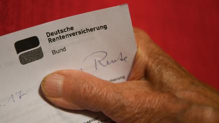  Eine Rentnerin hält ihren Rentenbescheid in der Hand. 