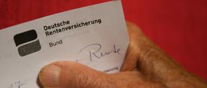  Eine Rentnerin hält ihren Rentenbescheid in der Hand. 